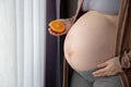 Pregnant woman holding sliced orange fruit Royalty Free Stock Photo