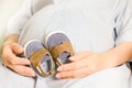 Pregnant woman holding small baby shoes in her hands. Royalty Free Stock Photo