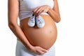 Pregnant woman holding small shoes for her new baby Royalty Free Stock Photo