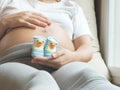 Pregnant woman holding small shoes for the unborn baby in front of the belly. Royalty Free Stock Photo