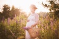 Pregnant woman holding a straw basket with wildflowers Royalty Free Stock Photo