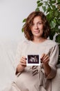 Pregnant woman holding ultrasound image. Concept of pregnancy, health care, gynecology, medicine. Young mother waiting Royalty Free Stock Photo