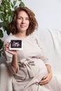 Pregnant woman holding ultrasound image. Concept of pregnancy, health care, gynecology, medicine. Young mother waiting Royalty Free Stock Photo