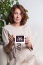 Pregnant woman holding ultrasound image. Concept of pregnancy, health care, gynecology, medicine. Young mother waiting Royalty Free Stock Photo