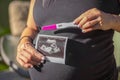 Pregnant Woman Holding an Ultrasound Picture of her Baby and a Pregnancy Test Royalty Free Stock Photo