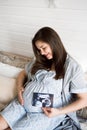Pregnant woman holding ultrasound scan. Pregnancy health concept.
