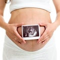 Pregnant woman holding ultrasound sonogram of