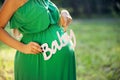 Pregnant woman holding word BABY