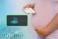 Pregnant woman holds blister with pills, capsules, ultrasound screen examination, small child rolls over in mother`s belly,