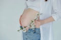 A pregnant woman holds a branch of a blossoming apple tree as a symbol of new life Royalty Free Stock Photo