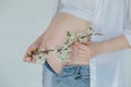 A pregnant woman holds a branch of a blossoming apple tree as a symbol of new life Royalty Free Stock Photo