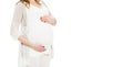 Pregnant woman holds hands on belly on a white background. Pregnancy, maternity, preparation and expectation concept. Close-up Royalty Free Stock Photo