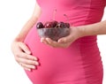 Pregnant woman holds a plate with cherry Royalty Free Stock Photo