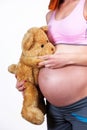 Pregnant woman holing teddy bear