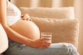 Pregnant woman at home holding glass of water Royalty Free Stock Photo