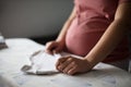 Pregnant woman at home preparing baby laundry