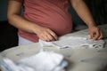 Pregnant woman at home preparing baby laundry