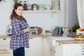 Pregnant woman housewife standing on kitchen and holding her large tummy