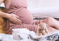 Pregnant woman hugging belly and packing maternity hospital bag. Beautiful mother during pregnancy waiting for baby preparing Royalty Free Stock Photo