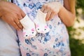 Pregnant woman with husband holding child`s bootees, closeup