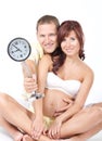 Pregnant woman with husband, holding a clock