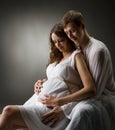 Pregnant woman with husband looking on belly