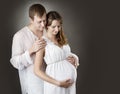 Pregnant woman with husband looking on belly