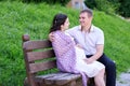 Pregnant woman and husband on outdoor, happy family, couple in city park, summer season, green grass and trees Royalty Free Stock Photo