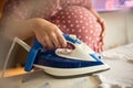 Pregnant woman ironing baby laundry at home Royalty Free Stock Photo