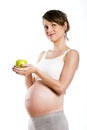 Pregnant woman isolated over white background, holding apple. Royalty Free Stock Photo