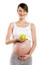 Pregnant woman isolated over white background, holding apple. Royalty Free Stock Photo