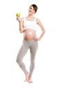 Pregnant woman isolated over white background, holding apple. Royalty Free Stock Photo