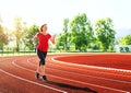 Pregnant woman jogging on running track in stadium. Royalty Free Stock Photo