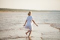 Pregnant woman jumping on the beach. Cheerful woman running on the seashore on her pregnancy at summer evening Royalty Free Stock Photo