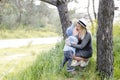 Pregnant woman with kid outdoors. Mother and her son on nature in spring forest. Little child boy kissing mother, who pregnant for Royalty Free Stock Photo
