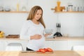 Pregnant woman in kitchen making salad Royalty Free Stock Photo