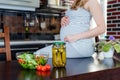 Pregnant woman in kitchen and pickled cucumbers. Healthy food.