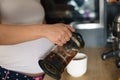 Pregnant woman in kitchen pour coffee