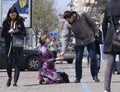 Pregnant woman kneeling on a pavement and begging, man giving change to her