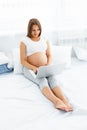 Pregnant woman with laptop. Beautiful pregnant woman working on