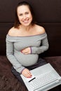 Pregnant woman with laptop and credit card at home Royalty Free Stock Photo