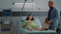 Pregnant woman laying in hospital ward bed waiting on assistance Royalty Free Stock Photo