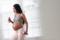 A pregnant woman lifts weights while at home Royalty Free Stock Photo
