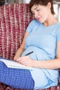Pregnant woman listing baby names Royalty Free Stock Photo