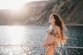 Pregnant woman with long hair in swimsuit on yacht