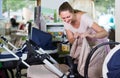 pregnant woman looking for baby carriage at kids shop