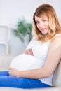 Pregnant woman looking at camera with hands on belly Royalty Free Stock Photo