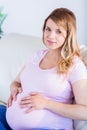 Pregnant woman looking at camera with hands on belly Royalty Free Stock Photo