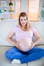 Pregnant woman looking at camera with hands on belly Royalty Free Stock Photo