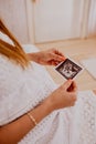 Pregnant woman looking at her baby twins sonography. Happy expectant mother enjoying first photo of her kids, face is Royalty Free Stock Photo